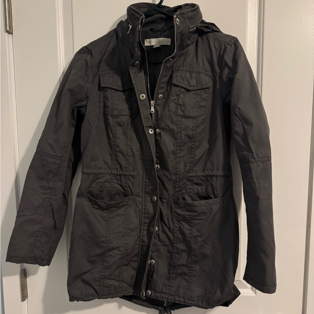 Gray utility coat. Ties inside, zips up, and has two outside (open) pockets